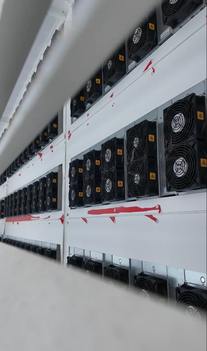 Rows of ASIC miners inside a container facility