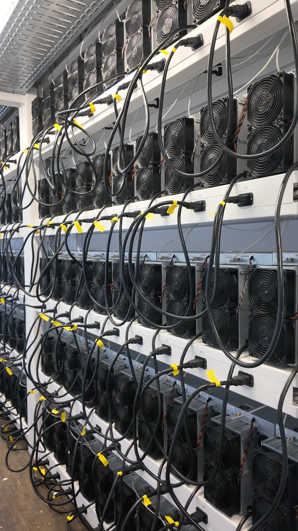 Rows of connected ASIC miners in a managed facility