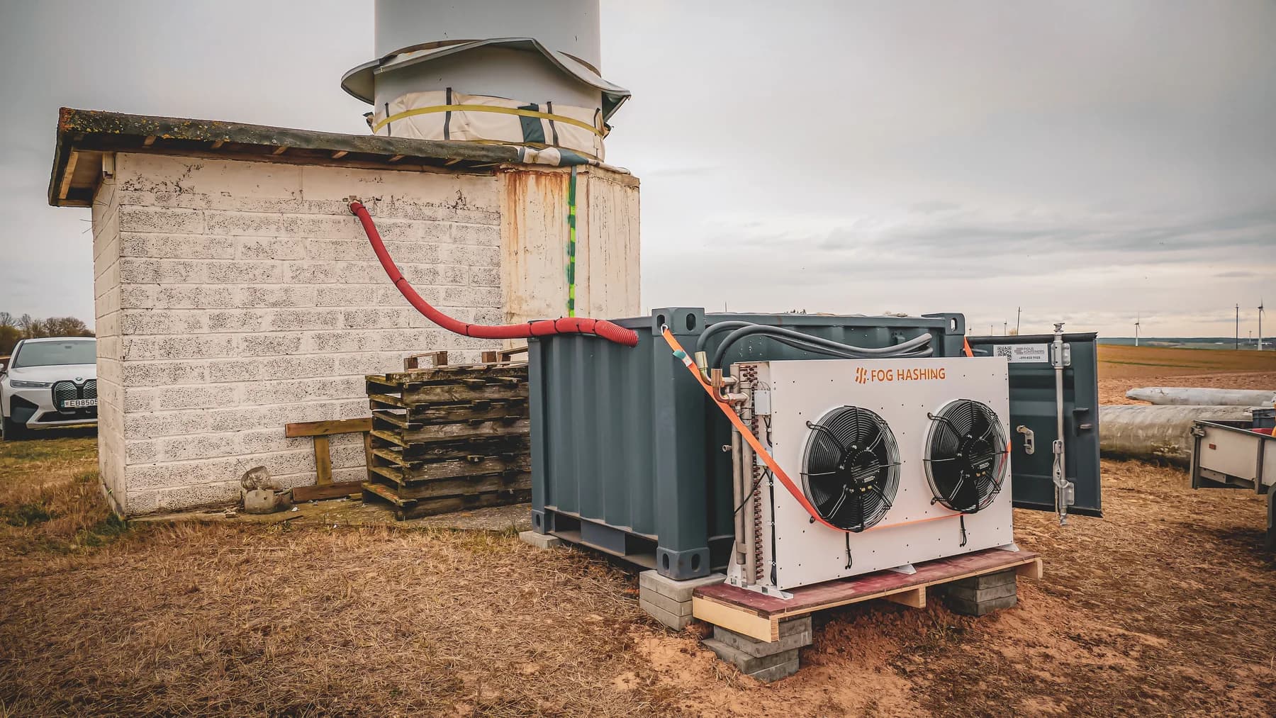 Containerized mining and cooling equipment installed near wind turbines in Lithuania